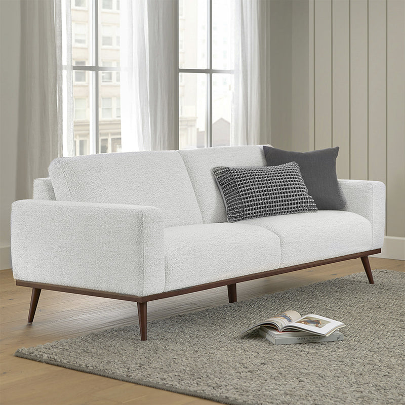SOFA ESTACIONARIO DE TRES ASIENTOS EN TELA BLANCA Y PATAS ACABADO DE MADERA